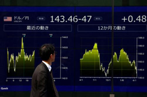 A passersby walks past an electronic screen displaying the exchange rate between Japanese yen and U.S. dollar in Tokyo, Japan, April 15, 2025.