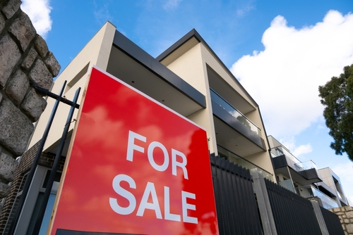 House with for sale sign.